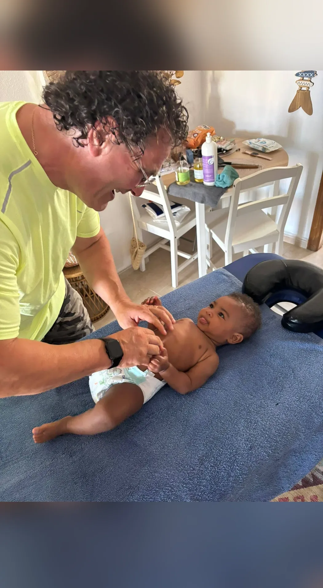 Pasqual massaging a baby while mum looks on