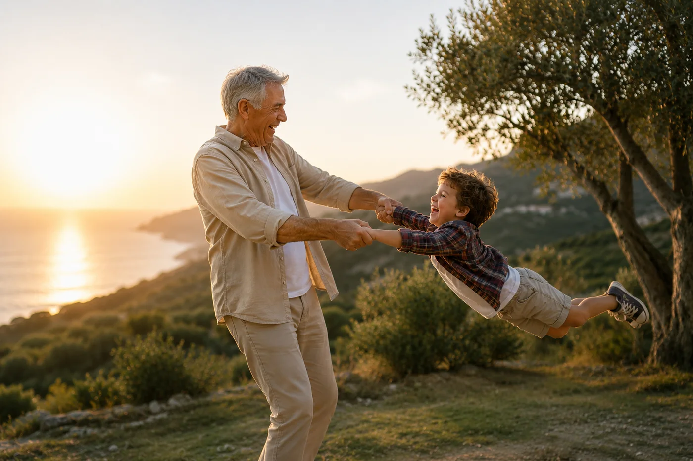 A grandfather swings his laughing grandson by the sea at sunset